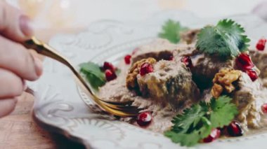 Altın çatalla tatmak ördek ve cevizli Satsivi. Geleneksel Gürcü yemekleri.
