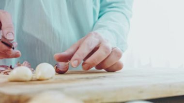 Sarımsağı masaya at. Çiftçi bir adam elinde sarımsak hasadı tutuyor. Seçici odak