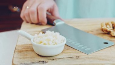 Kadın cevizi doğrar. Bıçağı kestikten sonra video titriyor..