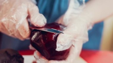 Kadın elleri mutfak tahtasındaki pancarı bıçakla kesmiş..