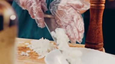 Aşçı soğanın nasıl küp kesileceğini gösteriyor..