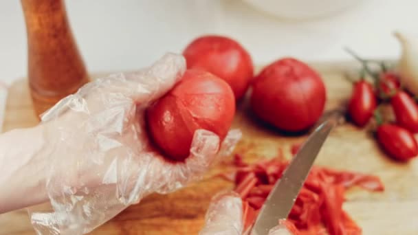 穿着红围裙的厨师把番茄切在锅里 放在旁边的桌子上 新鲜蔬菜 健康食品烹调菜的工艺 — 图库视频影像