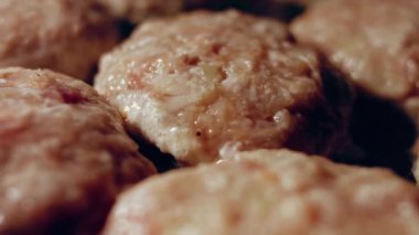 Juicy delicious meat cutlets are fried in oil on black pan. Simple home cooking