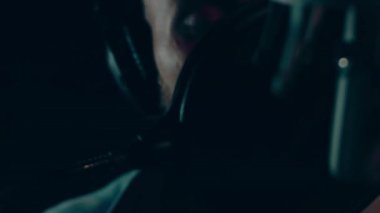 Profesyonel mikrofonlu yakışıklı rap şarkıcısının portresi modern stüdyoda şarkı söylüyor. Müzik prodüksiyonu. Zayıf ışık.