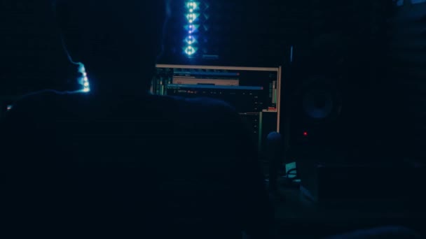 録音スタジオ サウンドエンジニアは コンピュータのモニター編集サウンドで動作します 録音のプロセス 現代の技術 音と声の補正 チャートのボリュームレベル スタジオでの悪い光 — ストック動画