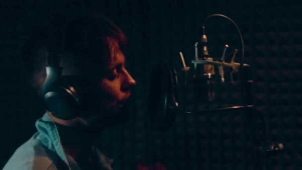 헤드폰에 전문적 마이크를 스튜디오에서 노래를 녹음하는 잘생긴 가수의 초상화 — 비디오
