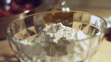 Undan elde edilen hamur işlemini kapat. Tavuk yumurtası ve cam kasede bir yığın beyaz un. Ravioli hazırlama işlemi. 4K video. Yavaş çekim.