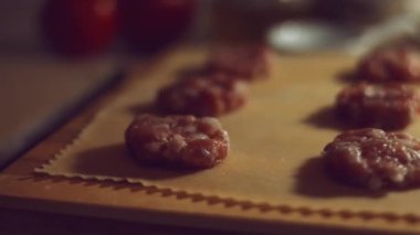 Eti hamurla kaplayan kadın eli yakın plan. Tipik bir İtalyan yemeği olan ravioli hazırlamak, eski İtalyan geleneğine göre ev yapımı. 4K video