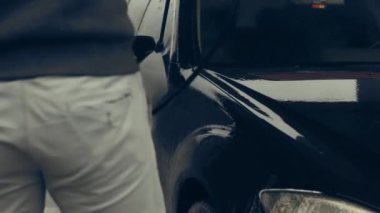 Beyaz köpükle kaplı ve su tabancasından sıçramış lüks araba yıkama işlemi. Parlak araba dış yüzeyine köpük saçılıyor. Güzel bir ortam. 4K video.