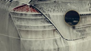 Beyaz köpükle kaplı ve su tabancasından sıçramış lüks araba yıkama işlemi. Parlak araba dış yüzeyine köpük saçılıyor. Güzel ortam.