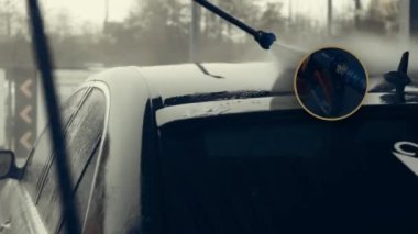 Beyaz köpükle kaplı ve su tabancasından sıçramış lüks araba yıkama işlemi. Parlak araba dış yüzeyine köpük saçılıyor. Güzel ortam.