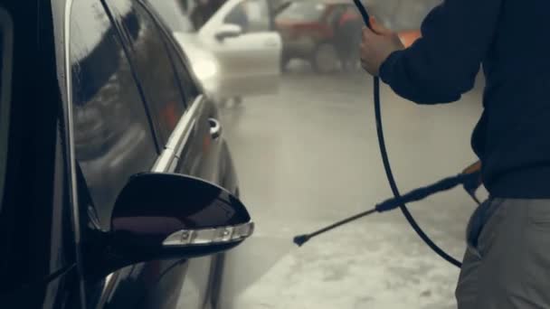 白い泡と水銃からのスプラッシュで覆われた高級車の車の洗浄プロセス 光沢のある車の外装に泡の広がり いい雰囲気だ 4Kビデオ — ストック動画