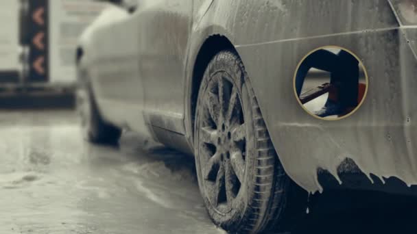 豪华轿车洗车过程中满载白色泡沫和水枪飞溅 把泡沫撒在闪闪发亮的汽车外部 气氛很好 — 图库视频影像