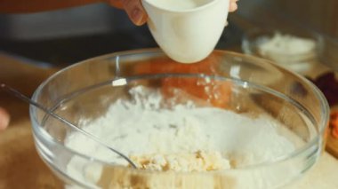 Taze yumurta ve çelik el karıştırıcıyı cam bir kasede karıştırmak. Un ekliyorum. Krep hazırlama süreci. 4K video.