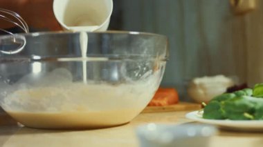 Taze yumurta ve çelik el karıştırıcıyı cam bir kasede karıştırmak. Un ekliyorum. Krep hazırlama süreci. 4K video.