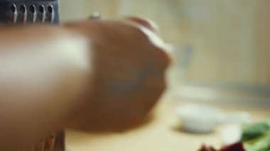 Ev mutfağındaki öğütücüye havuç süren kadın eli. 4K video.