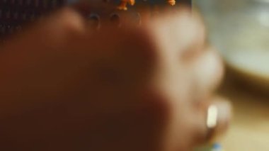 Ev mutfağındaki öğütücüye havuç süren kadın eli. 4K video.