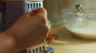 Ev mutfağındaki öğütücüye havuç süren kadın eli. 4K video.