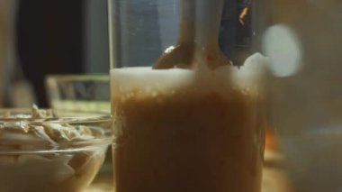 Malzemeleri el blenderiyle karıştırmadan önce krep hamuruna havuç eklemek. Renkli krep hazırlama süreci. 4K video.