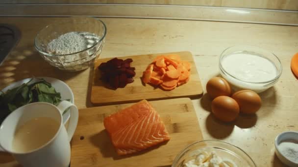 薄いおいしいカラフルなパンケーキ クリームチーズとサーモンのフィリングで赤 緑のロールパンケーキを準備するための成分のトップビュー 4Kビデオ — ストック動画