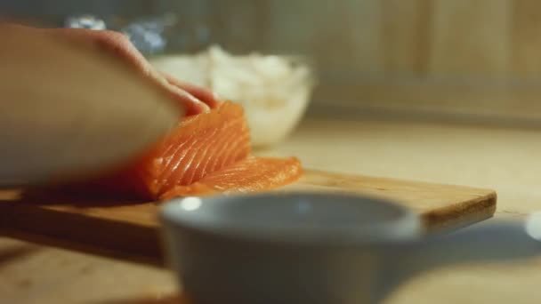 木の板に新鮮な鮭の切り身をスライス女性の手のクローズアップ 4Kビデオ タイムラプス — ストック動画