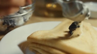Krep üzerine taramasalata katılmış siyah balık yumurtası yaymak. İzole edilmiş yakın çekim makro. 4K video.
