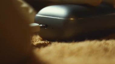 Şarj çantasındaki kablosuz kulaklıkların makro görüntüsü. Erkekler bir kulaklığı davadan alıp gösteriyorlar. 4K video.