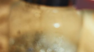 Sıcak suyla şeffaf bir fincana çay yaprakları ve çiçekler dökmek. Sri Lanka 'dan gelen aromatik ve rahatlatıcı çay hazırlanıyor. Sağlıklı yaşam tarzı kavramı. 4K video.