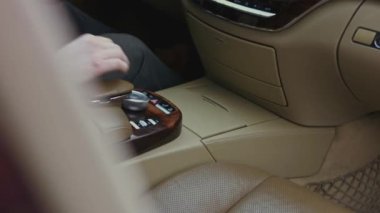 Sürücüler, arabanın parlak gösterge panelindeki tehlike uyarısı tuşuna basıyorlar. Düğme kırmızı yanıp sönüyor. Lüks araba iç mekanı. - Yakın çekim. 4K video.