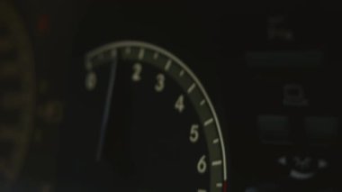 Araba hız göstergesini kapat. Görüntü. Modern bir arabanın içi, hızlı arama motoru ve hareket eden oku olan gösterge paneli. 4K video. Odaklanmamış.