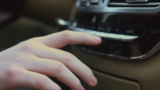 車のエアコンボタンを調整する手の閉まり 自動車の空調システムを使う男 車の中でデュアル気候制御 高級車のインテリア 4Kビデオ — ストック動画