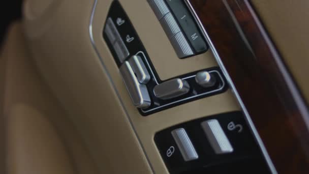 車内の電動シート調整のための制御ボタンを押す男性の手のクローズアップビュー 内部ドアシートはボタンスイッチを調整します 4Kビデオ — ストック動画