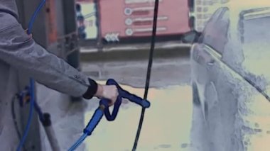 Vitiligo 'su olan genç stil sahibi bir adam oto yıkamada araba temizlemek için yüksek basınçlı jet suyu kullanıyor. 4K video.