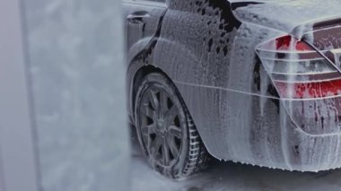 Oto yıkama, oto yıkama, yukarıdan görüş. Yerden köpük boşalıyor. 4K video.