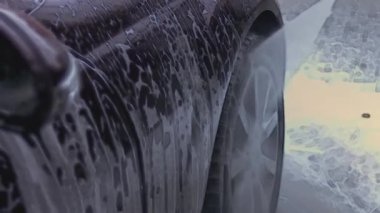 Oto yıkama, oto yıkama, yukarıdan görüş. Yerden köpük boşalıyor. 4K video.