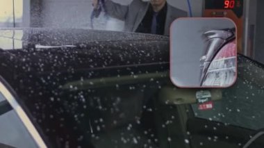 Vitiligo 'su olan genç stil sahibi bir adam oto yıkamada araba temizlemek için yüksek basınçlı jet suyu kullanıyor. 4K video.