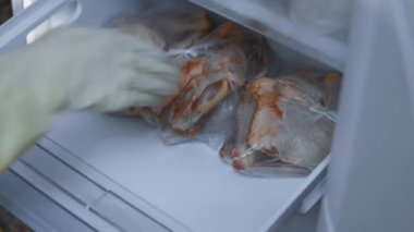 Meat stock, meat reserve during the COVID-19 pandemic. Chicken meat storage and organization in a freezer. Woman puts in the fridge cut chicken. Timelapse. 4K video.
