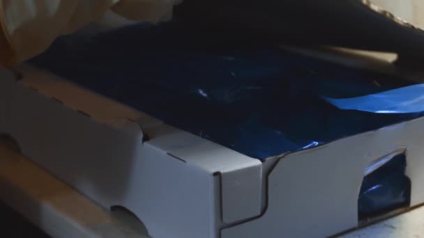 冷凍鶏の足がいっぱいの箱を開ける手袋で手のクローズアップビュー 氷で覆われた冷凍生鶏の肉 4Kビデオ — ストック動画