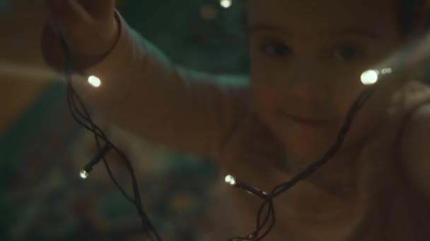 家家户户装饰他们的圣诞假期 美丽快乐的女孩有乐趣与灯玩耍和拥抱 圣诞快乐 节日快乐 快乐的家庭时光 — 图库视频影像