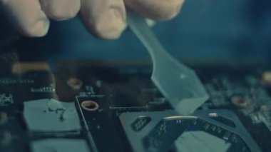GPU Grafik Kartı. Teknisyenlerin el ile yeni termal macunu çipin üzerine yaymasını gösteren makro görüş. 4K video