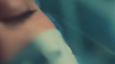 İşi bitirdikten sonra kameraya bakan kendine güvenen doktorların yorgun gözleri. Tıbbi koruyucu maskeyi çıkarıp nefes alan bir kadının yakın plan yüzü. Koronavirüs salgını sırasında hastanede çalışmak.