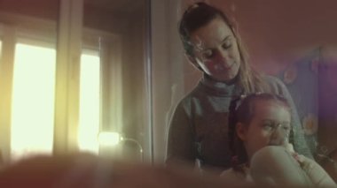 Güzel küçük kız kanepede otururken kompresör spreyiyle solunum yapıyor. Beş yıl oldu. Yüzünde nebulizör maskesiyle salin buharı soluyan bir kız. Anne kızının nefes almasına yardım ediyor.