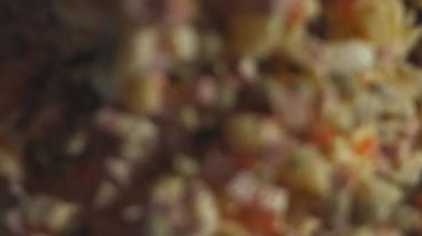 Beyaz tabakta Olivier salatası, rendelenmiş yumurta ile süslenmiş. Geleneksel Yeni Yıl ve Noel Rus salatası. Yakın çekim, 4K video. Yavaş çekim.