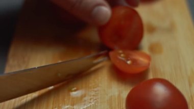 İki kiraz domatesini ahşap bir şişle birleştirip kahvaltıda kızarmış yumurtayla tabağa koymak. 4K video. Sanatsal çekim.