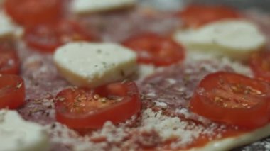 Fırın tepsisinde dilimlenmiş kiraz domatesleri kalp şeklinde pizzaya ekliyorum. Sevgililer Günü için kalp şeklinde pizza hazırlıyorum. Sevdiğim biri için. 4K video. Sanatsal çekim.