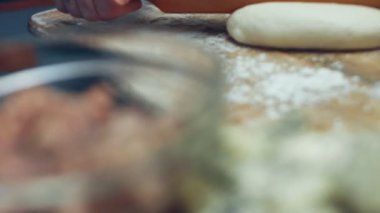 Tahta kesme tahtasının üzerinde ton balıklı pizza için taze hamur hazırlıyorum. Sevgililer Günü için kalp şeklinde ton balıklı pizza hazırlıyorum. 4K video.