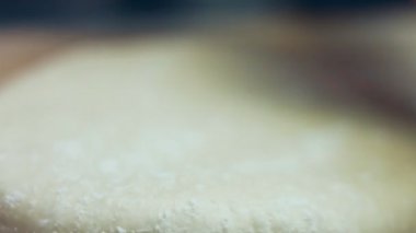 Tahta kesme tahtasının üzerinde ton balıklı pizza için taze hamur hazırlıyorum. Sevgililer Günü için kalp şeklinde ton balıklı pizza hazırlıyorum. 4K video.