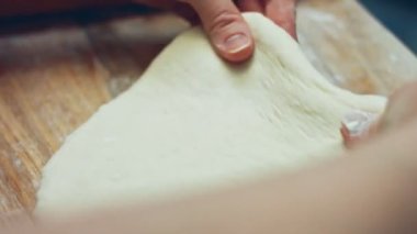 Tahta kesme tahtasının üzerinde ton balıklı pizza için taze hamur hazırlıyorum. Sevgililer Günü için kalp şeklinde ton balıklı pizza hazırlıyorum. 4K video.