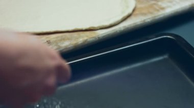 Tahta kesme tahtasının üzerinde ton balıklı pizza için taze hamur hazırlıyorum. Sevgililer Günü için kalp şeklinde ton balıklı pizza hazırlıyorum. 4K video.