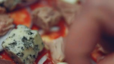 Pizzanın üzerine başka malzemelerle parmesanlı peynir serpiştirmek. Sevgililer Günü için kalp şeklinde ton balıklı pizza hazırlıyorum. 4K video.